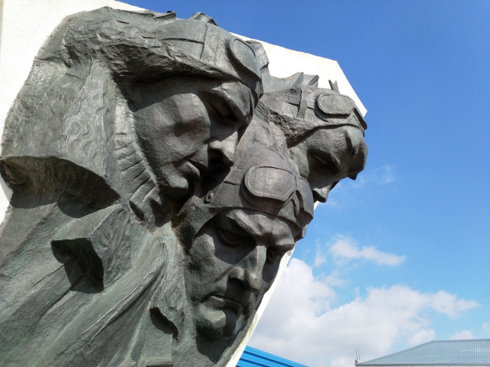 Charków - Pomnik Lotników. Pomnik przedstawia twarze czterech mężczyzn. Wszyscy noszą lotnicze czapki i gogle.